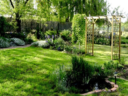 View across top garden from small pond.with arch